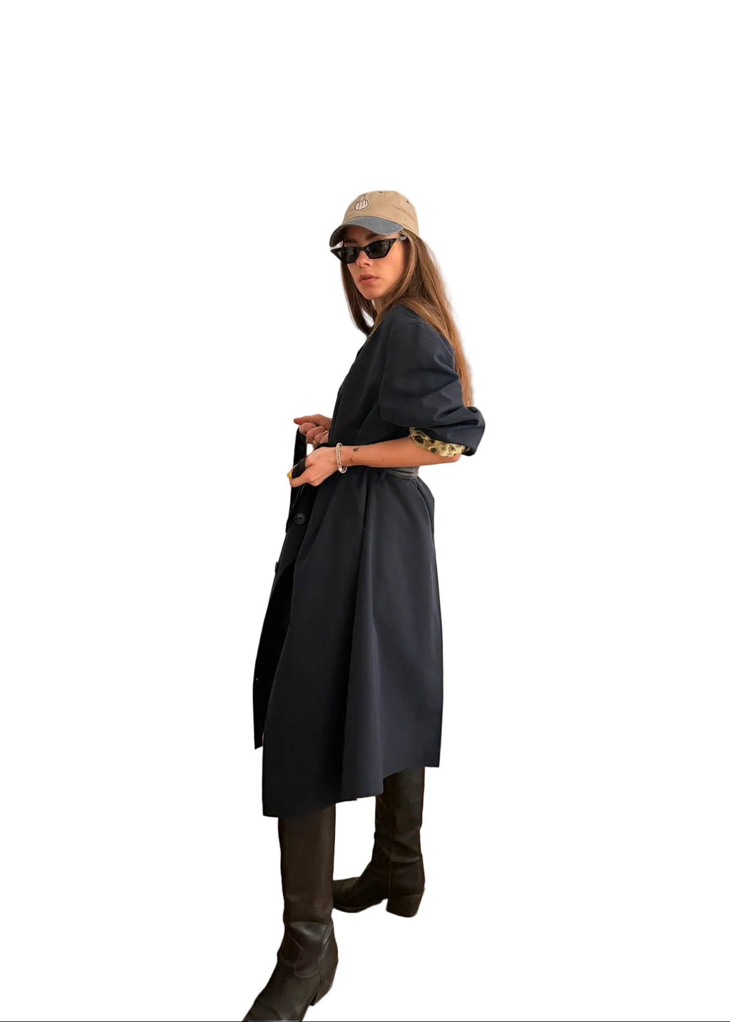 Person wearing a dark coat and hat in a room with a white door and beige sofa.